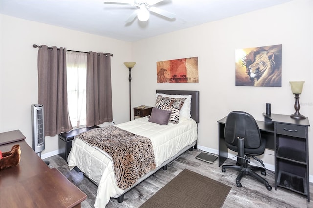 bedroom featuring baseboards, a ceiling fan, and wood finished floors