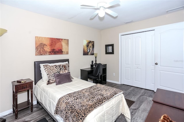 bedroom featuring baseboards, wood finished floors, visible vents, and a closet
