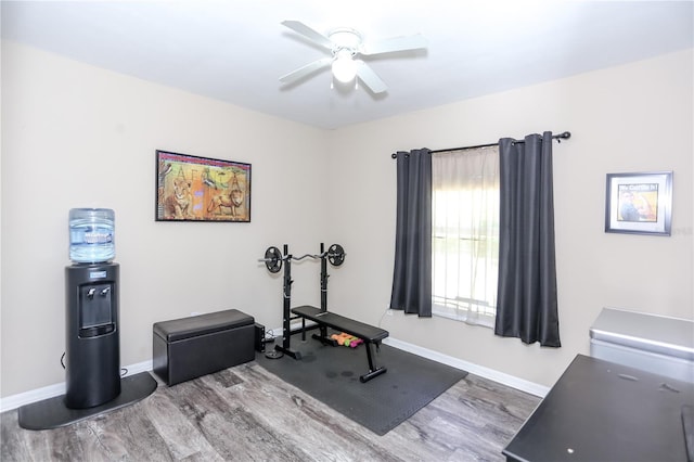 exercise room with baseboards, wood finished floors, and ceiling fan