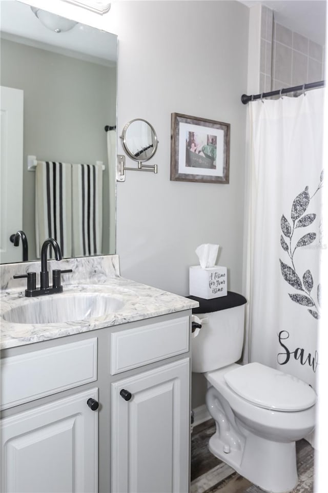 bathroom featuring curtained shower, toilet, and vanity