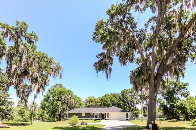 view of front facade featuring driveway, a garage, and a front yard