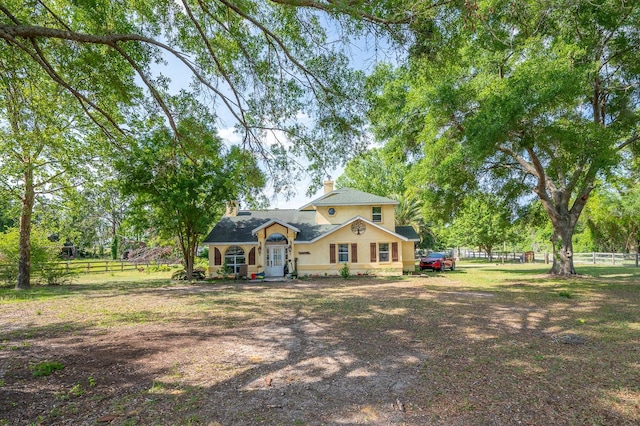view of front of house with a chimney and fence
