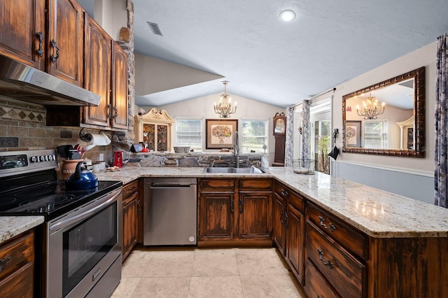 kitchen with vaulted ceiling, appliances with stainless steel finishes, a chandelier, and under cabinet range hood