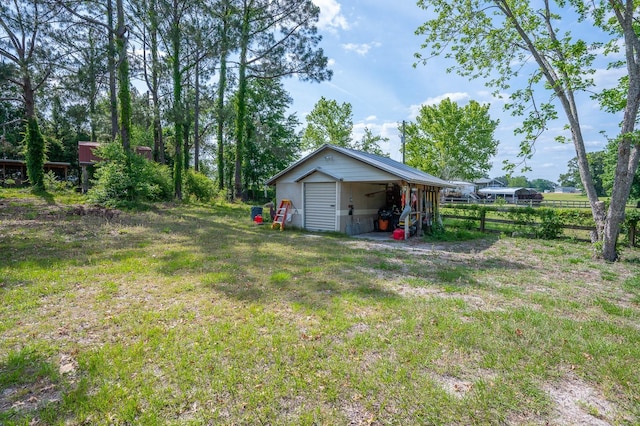 view of yard with fence and an outbuilding