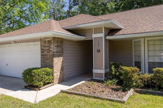 3653 NW 67th Ave, Gainesville, FL 32653 - view of exterior entry with a garage and a shingled roof