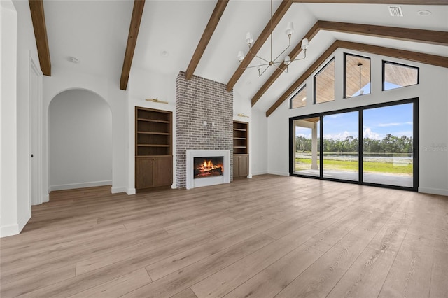 unfurnished living room with built in features, baseboards, beamed ceiling, and high vaulted ceiling