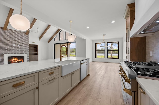 kitchen featuring hanging light fixtures, a sink, stainless steel appliances, backsplash, and custom exhaust hood