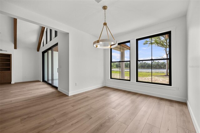 unfurnished dining area featuring baseboards, a chandelier, and light wood-style flooring