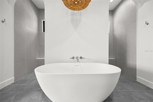 bathroom with baseboards and a soaking tub