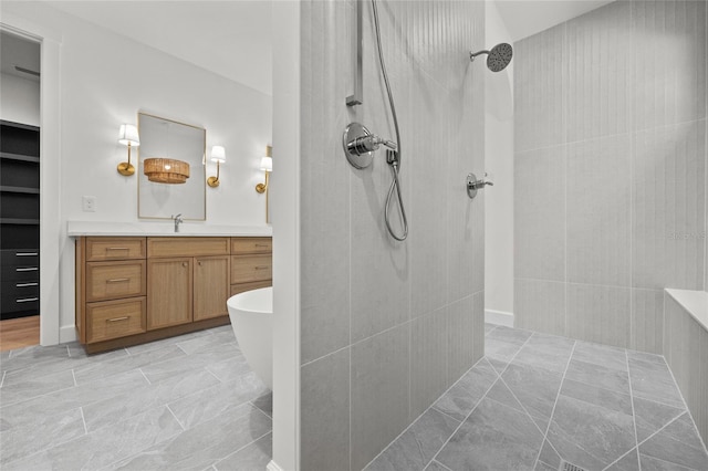 full bath with a freestanding bath, vanity, and a tile shower