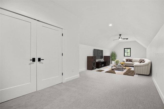 carpeted living area featuring baseboards, a ceiling fan, and lofted ceiling
