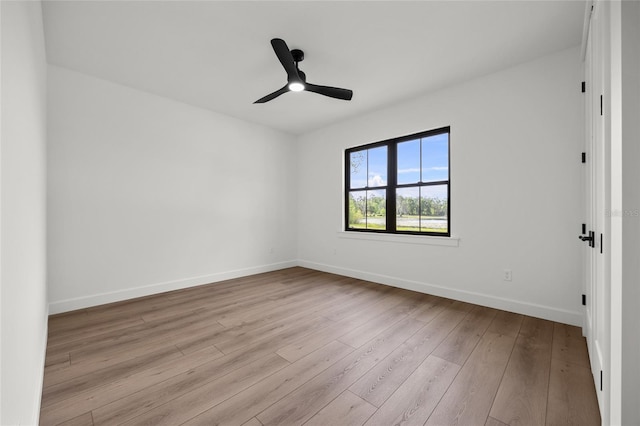 unfurnished room featuring wood-type flooring, a ceiling fan, and baseboards