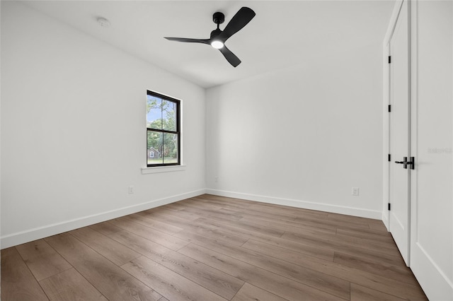 spare room with baseboards, a ceiling fan, and wood finished floors