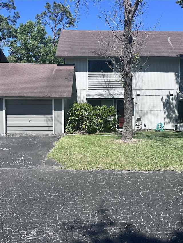 4606 NW 41st Pl Unit 107, Gainesville, FL 32606 - view of front of home with roof with shingles, an attached garage, driveway, and a front yard