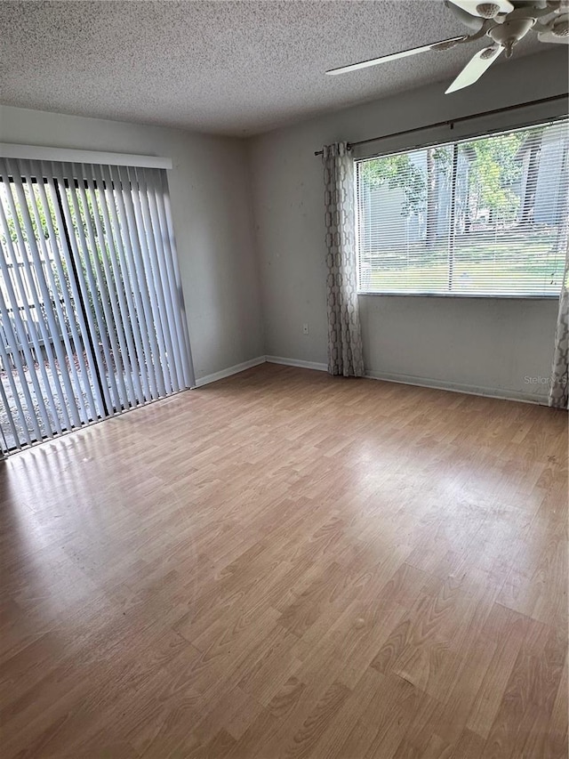 4606 NW 41st Pl Unit 107, Gainesville, FL 32606 - empty room featuring a textured ceiling, baseboards, a ceiling fan, and wood finished floors