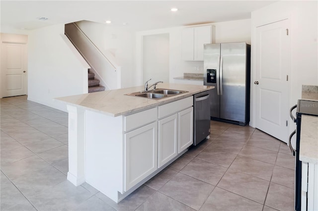 6683 SE 3rd Loop, Ocala, FL 34472 - kitchen with a sink, stainless steel appliances, an island with sink, light tile patterned floors, and white cabinets