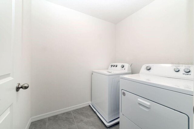 6683 SE 3rd Loop, Ocala, FL 34472 - laundry room featuring washer and dryer, laundry area, light tile patterned floors, and baseboards