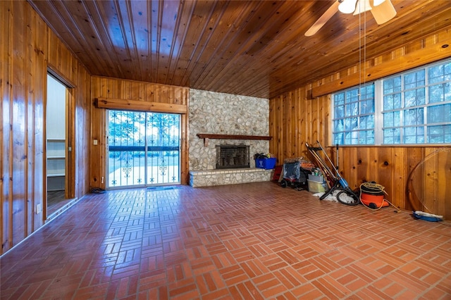 3436 SW 20th St, Gainesville, FL 32608 - unfurnished living room with ceiling fan, wooden walls, brick floor, and a fireplace
