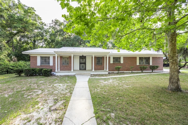 3436 SW 20th St, Gainesville, FL 32608 - single story home featuring a front yard, metal roof, a porch, and brick siding