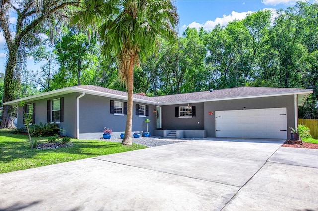2423 NW 67th Ter, Gainesville, FL 32606 - ranch-style home with a garage, driveway, a front lawn, and stucco siding