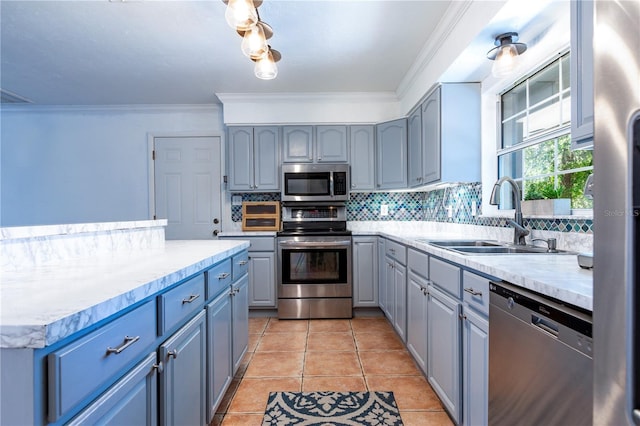 2423 NW 67th Ter, Gainesville, FL 32606 - kitchen featuring gray cabinets, decorative backsplash, appliances with stainless steel finishes, and a sink