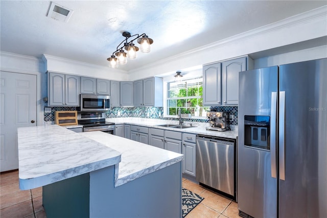 2423 NW 67th Ter, Gainesville, FL 32606 - kitchen with stainless steel appliances, a sink, visible vents, gray cabinets, and ornamental molding