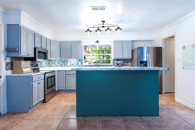 2423 NW 67th Ter, Gainesville, FL 32606 - kitchen with a center island, crown molding, gray cabinets, appliances with stainless steel finishes, and visible vents