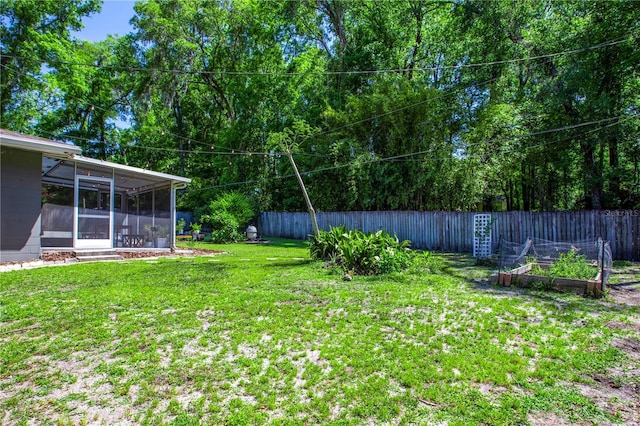 2423 NW 67th Ter, Gainesville, FL 32606 - view of yard featuring a garden, a fenced backyard, and a sunroom