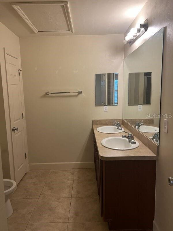 2927 SW 35th Pl Unit 115, Gainesville, FL 32608 - bathroom with baseboards, tile patterned flooring, a sink, and double vanity