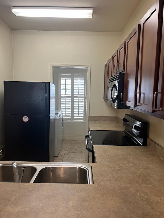 2927 SW 35th Pl Unit 115, Gainesville, FL 32608 - kitchen with light countertops, independent washer and dryer, and black appliances