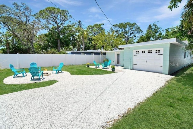 418 40th Ave S, Saint Petersburg, FL 33705 - view of yard featuring a fire pit, driveway, a garage, and a patio