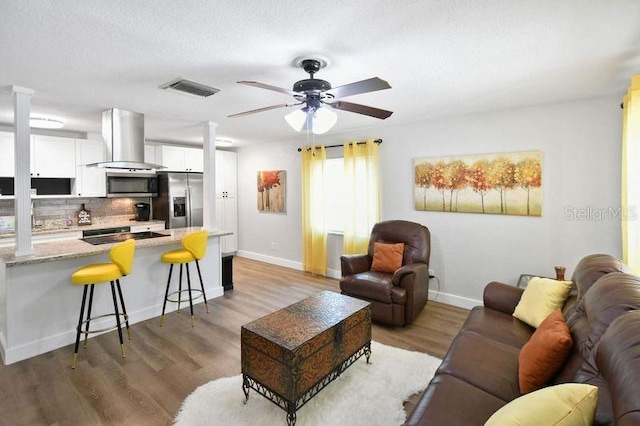 418 40th Ave S, Saint Petersburg, FL 33705 - living area with ceiling fan, light wood-style flooring, baseboards, and decorative columns