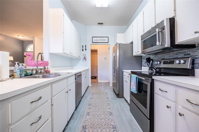6114 NW 35th St, Gainesville, FL 32653 - kitchen with appliances with stainless steel finishes, white cabinetry, light countertops, and a sink