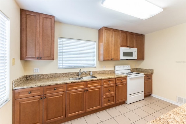 6114 NW 35th St, Gainesville, FL 32653 - kitchen featuring brown cabinets, visible vents, white appliances, and a sink