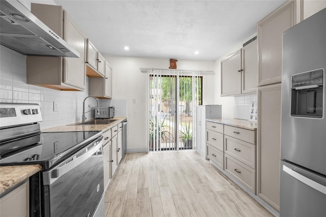 507 NW 39th Rd Unit 317, Gainesville, FL 32607 - kitchen featuring appliances with stainless steel finishes, extractor fan, a sink, light wood finished floors, and recessed lighting