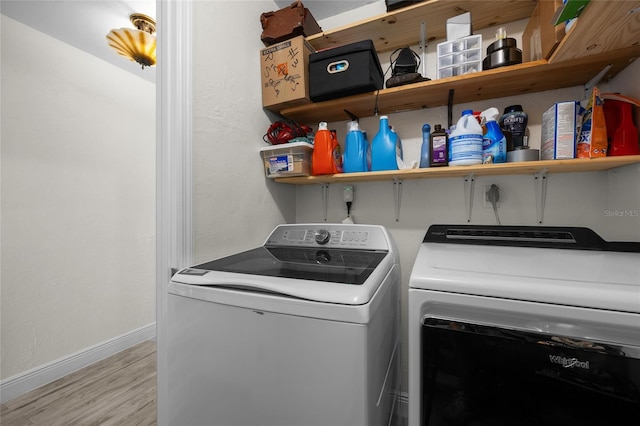 507 NW 39th Rd Unit 317, Gainesville, FL 32607 - laundry area featuring washing machine and clothes dryer, light wood finished floors, and baseboards