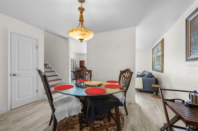 507 NW 39th Rd Unit 317, Gainesville, FL 32607 - dining area with light wood-style flooring, stairway, and baseboards