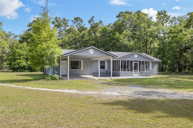 back of property featuring a sunroom and a lawn