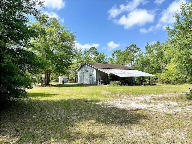 view of yard with a garage, a storage unit, a pole building, and an outbuilding