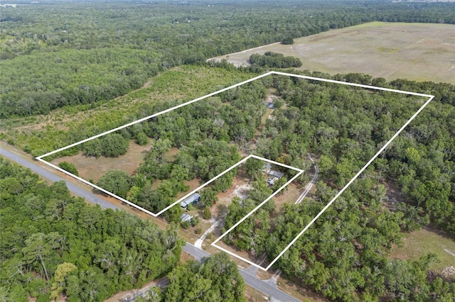 birds eye view of property featuring a forest view