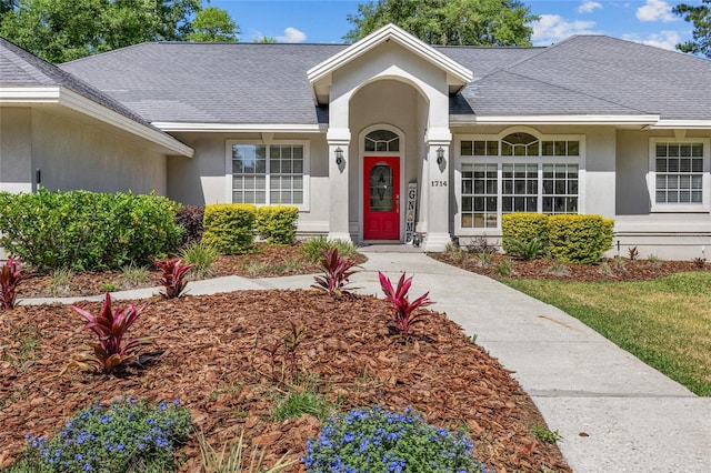 view of front of home with stucco siding and a shingled roof