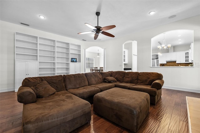 living area featuring arched walkways, a chandelier, ceiling fan, dark wood-style floors, and recessed lighting