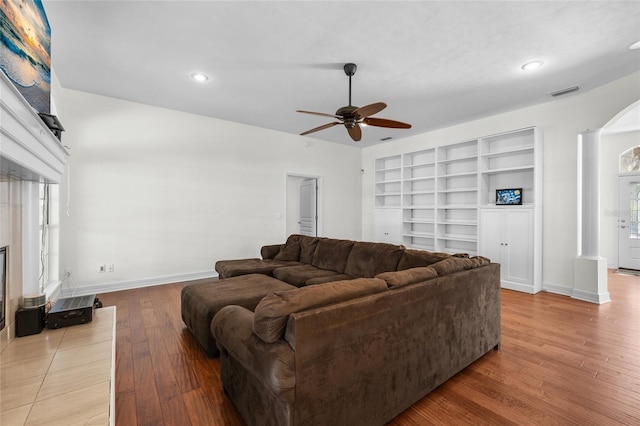 living room with ceiling fan, wood finished floors, baseboards, recessed lighting, and arched walkways