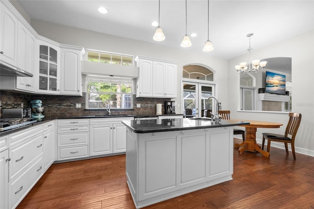 kitchen with a sink, backsplash, white cabinetry, and recessed lighting