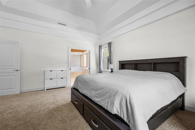 bedroom featuring light colored carpet, a ceiling fan, connected bathroom, and baseboards