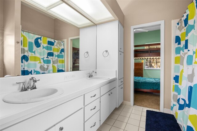 bathroom with tile patterned flooring, double vanity, and curtained shower