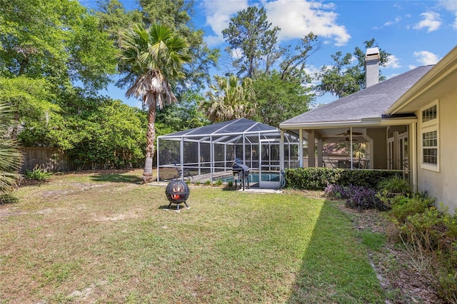 view of yard featuring an outdoor pool, a fire pit, and glass enclosure