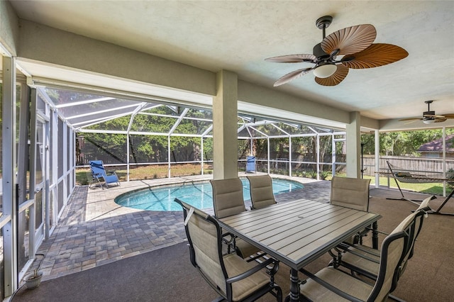 view of swimming pool with a patio area, a fenced backyard, ceiling fan, and glass enclosure