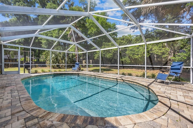 swimming pool featuring a fenced backyard, a patio, and glass enclosure