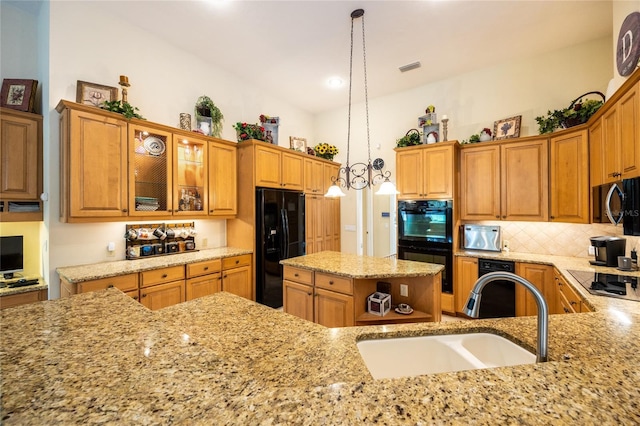 10312 SW 23rd Ave, Gainesville, FL 32607 - kitchen featuring black appliances, a sink, light stone countertops, tasteful backsplash, and decorative light fixtures